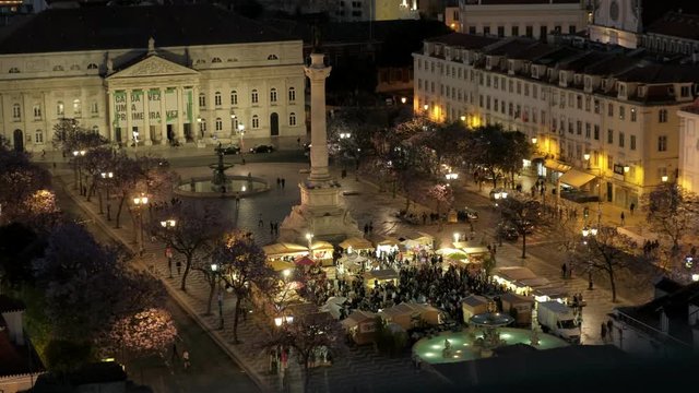 Elevated static long shot of Rossio Square in Lisbon at night