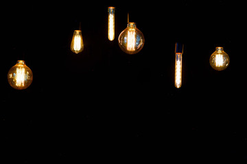 Vintage lamps with wires hang on the wall in the old-fashioned interior.