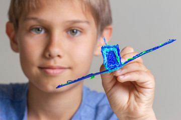 Kid creating with 3d pen and enjoy his new blue plane