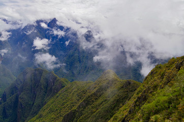 Panoramic view from Machu Picchu Mountain onto mountains and valleys and ruins of lost city of Inka...