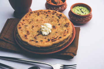 Aloo Paratha / Indian Potato stuffed Flatbread with butter on top. Served with fresh sweet Lassi, chutney and pickle . selective focus