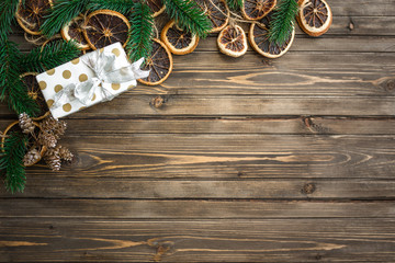 Christmas background with decorations, gift box and mandarins on wooden board. Copy space