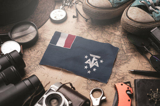 French Southern Flag Between Traveler's Accessories on Old Vintage Map. Tourist Destination Concept.