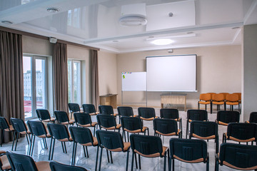 classroom auditorium with chairs tables and blackboard