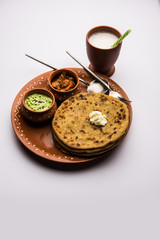 Aloo Paratha / Indian Potato stuffed Flatbread with butter on top. Served with fresh sweet Lassi, chutney and pickle . selective focus