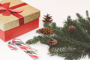 Christmas concept, gifts box, branches,fir cones and candy canes against a white background.