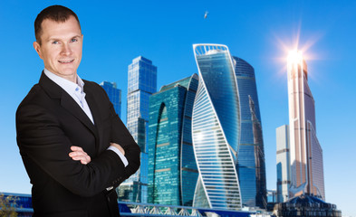 Businessman with crossed hands over cityscape background.