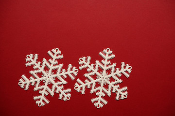  Christmas decoration of three white stars snowflakes on red background.        
