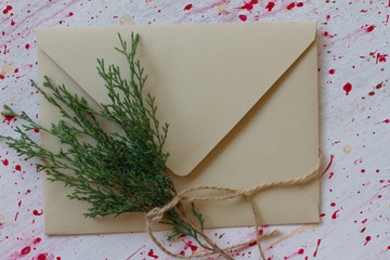 a letter with a white sheet in an envelope, lying on the table, with a sprig of Christmas tree. Christmas background for greeting card. The new year 2020. the view from the top. space for text.