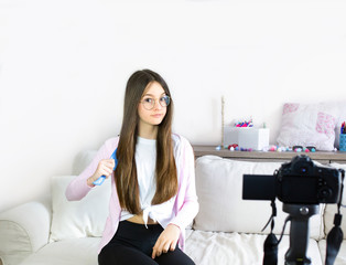 Teen girl blogger presents beauty products, combs and transmits live video to social networks....