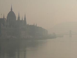 Fototapeta na wymiar Silhouette of the neo-Gothic palace in the parliament of budapest on the danube river shrouded in fog.