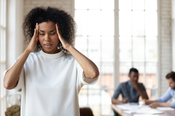 African ethnic company employee feeling strong headache.