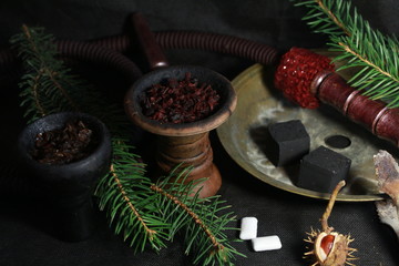 bowl with tobacco for hookah. fruits on a black background. smoking hookah