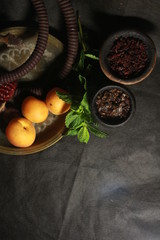 bowl with tobacco for hookah. fruits on a black background. smoking hookah