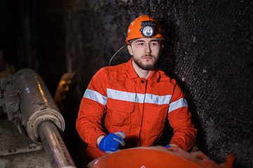 profession of a miner. A young miner in a coal mine in the generals is busy with work, repairing...