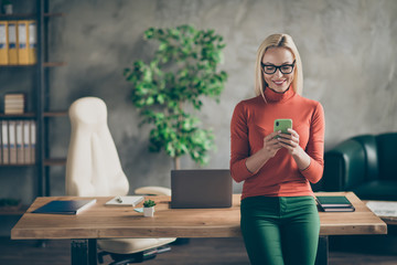 Portrait of smart company owner woman use smartphone chatting with employees colleagues stand near...