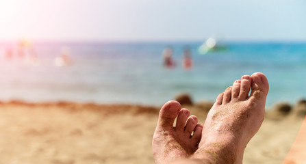 bare feet in the sand against the beach, the concept of a beach holiday