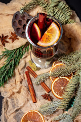 Christmas composition with mulled wine, oranges and branches of spruce on a dark black background. Winter drink. Hot Christmas Mulled Wine.
