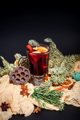 Christmas composition with mulled wine, oranges and branches of spruce on a dark black background....