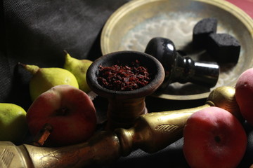 bowl with tobacco for hookah. passion fruit on a dark background. smoking hookah