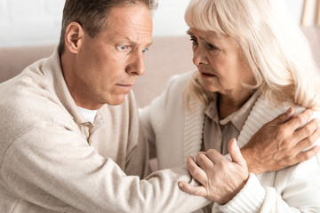 Obraz na płótnie Canvas senior man with alzheimer disease sitting near worried wife