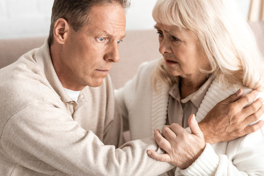 senior man with alzheimer disease sitting near worried wife