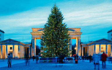 Brandenburg Gate Building in Berlin, Germany. Illuminated at night. Christmas Tree at street in...