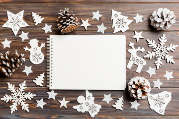 Top view of notebook on wooden background made of Christmas decorations. New Year concept