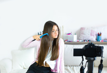 Teen girl blogger presents beauty products, combs and transmits live video to social networks....