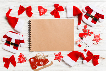 Fototapeta premium Top view of notebook on wooden background made of Christmas decorations. New Year concept