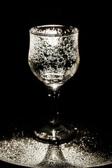 Empty wine glass silhouette over black. evening setup with a wine glass and blurry lights ** Note: Shallow depth of field.