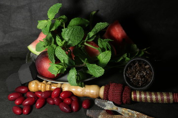 bowl with tobacco for hookah. fruits on a dark background. smoking sheesha