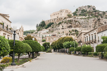SCICLI, ITALY - OCTOBER 3, 2019: street with paving stones on road near old church and buildings in scicli