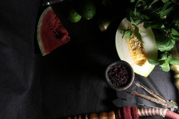 bowl with tobacco for hookah. fruits on a dark background. smoking shisha