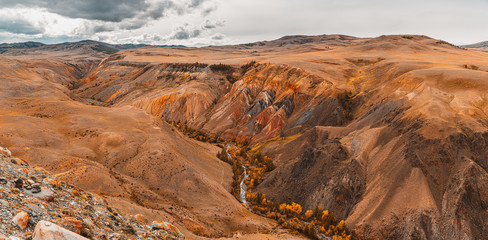 Panorama gorge in mountains. Beautiful Landscape red mountains in cloudy weather. Gorge Martian landscapes. Panorama of desert landscape on Altai, in Russia