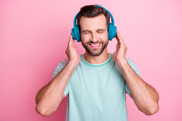 Peaceful positive modern man have blue wireless headset listen music enjoy song melody close eyes feel pleasure wear casual style clothes isolated over pastel color background