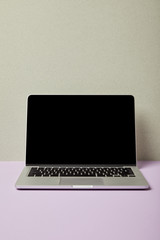 laptop with blank screen on grey and purple