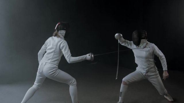 Fencing training in the studio - two women having a duel