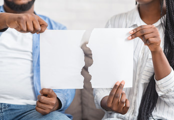 African american couple holding torn piece of paper