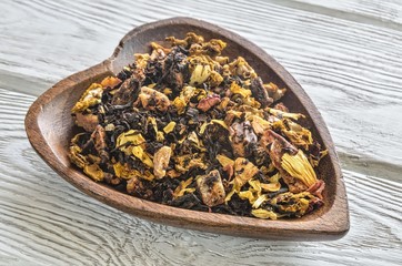 Fototapeta na wymiar Tea in the kitchen. Colorful fruit tea in a wooden dish.