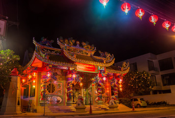 Fototapeta na wymiar Traditional Chinese Temple decorated for The New Year with red lights on the street at night. Chao Eng Sae Shrine, Mae Nam, Koh Samui. Public place