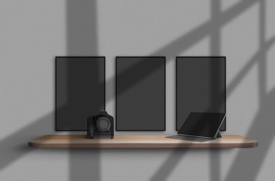 Camera and tablet on wooden shelf, suspended from gray wall with shadows from window on it. Three blank banners hanging above it. Mockup. Close-up.