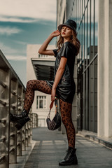 Outdoor full body street fashion portrait of young elegant model, woman wearing trendy leather...