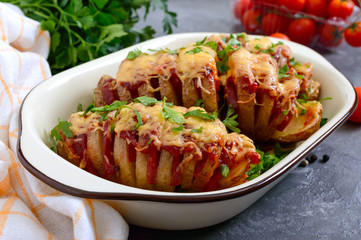 Hasselback potato stuffed with salami, cheese, ketchup, garlic and herbs. Baked whole potatoes is...