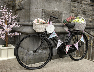 Fototapeta na wymiar Old bicycle full of flowers outside a church for wedding