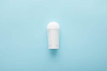 top view of roll on bottle of deodorant on blue background