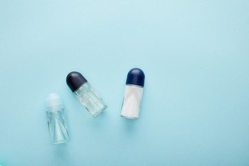 top view of roll on bottles of deodorant on blue background