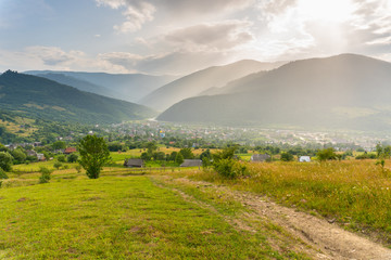 Fototapeta na wymiar Amazing view on valley with village between mountains under summer rain