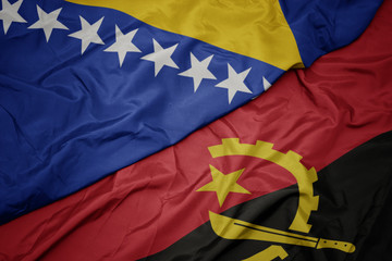 waving colorful flag of angola and national flag of bosnia and herzegovina.