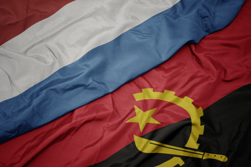 waving colorful flag of angola and national flag of luxembourg.